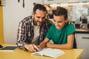 Father is helping his son with learning. They are doing homework together. photo