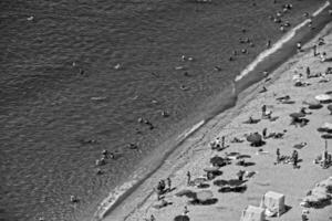 un pintoresco playa ver con un aves ojo ver lleno de personas descansando en vacaciones foto