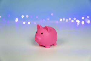 Pink piggy bank on a New Year's Christmas background with festive lights photo