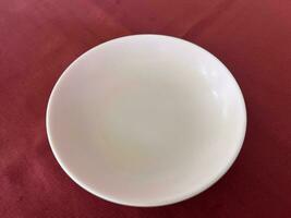 blanco plato en rojo mesa foto