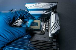 computer processor in a gloved hand against the background of the motherboard photo