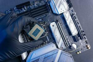computer processor in a gloved hand against the background of the motherboard photo
