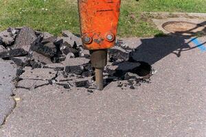 Professional heavy machinery destroys old concrete pavement photo