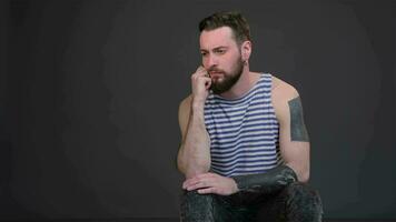 Young bearded man taking thought isolated on dark gray background video