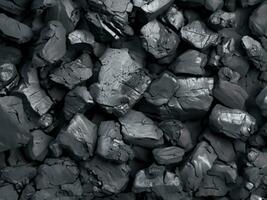 pile of charcoal isolated on black background. top view photo