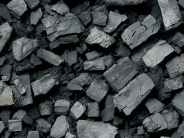 pile of charcoal isolated on black background. top view photo