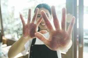 The artist creates a frame with her hands soiled with watercolor paints. photo