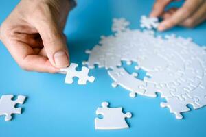 Hand holding a jigsaw puzzle. jigsaw puzzle Solve problems working together Organize team building connection plan Choosing the right business. photo