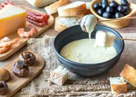 Bowl of fondue with appetizers photo