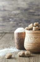 Bowls of white and brown sugar on the wooden background photo