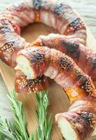 Bagels with sesame wrapped in bacon rashers photo