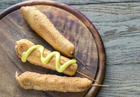 Corn dogs on the wooden board photo