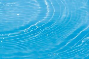 Defocus blurred transparent blue colored clear calm water surface texture with splashes reflection. Trendy abstract nature background. Water waves in sunlight with copy space. Blue watercolor shine. photo