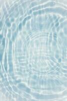 desenfoque borroso transparente color azul claro agua tranquila textura superficial con salpicaduras y burbujas. fondo de naturaleza abstracta de moda. ondas de agua a la luz del sol con espacio de copia. acuarela azul brillante foto