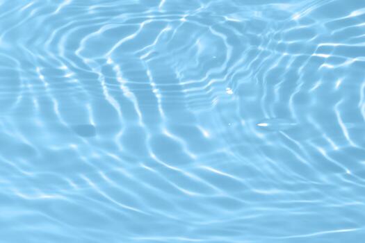 Blue water with ripples on the surface. Defocus blurred transparent blue colored clear calm water surface texture with splashes and bubbles. Water waves with shining pattern texture background. photo