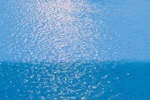 Defocus blurred transparent blue colored clear calm water surface texture with splashes reflection. Trendy abstract nature background. Water waves in sunlight with copy space. Blue watercolor shine. photo