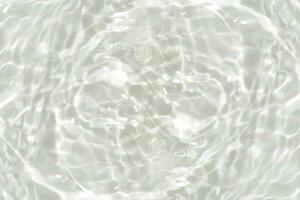 Blue water with ripples on the surface. Defocus blurred transparent blue colored clear calm water surface texture with splashes and bubbles. Water waves with shining pattern texture background. photo