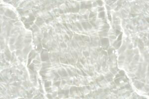 Blue water with ripples on the surface. Defocus blurred transparent blue colored clear calm water surface texture with splashes and bubbles. Water waves with shining pattern texture background. photo