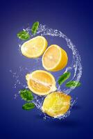 Water Splashing on yellow lemon fruit over blue background. photo