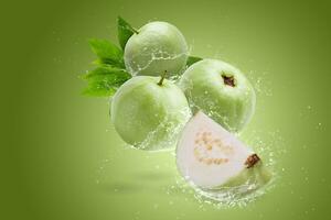 Water splashing on Guava fruit isolated on a green background photo