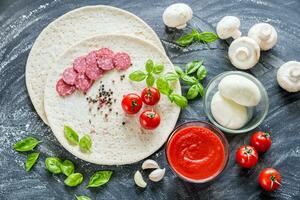 Pizza ingredients on the dark wooden background photo