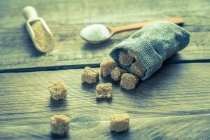 Brown and white sugar on the wooden background photo