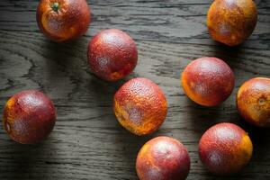 Red tangerines on the wooden background photo