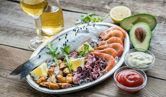 Fresh seabass with seafood on the tray photo