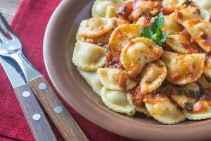 Portion of ravioli with marinara sauce photo