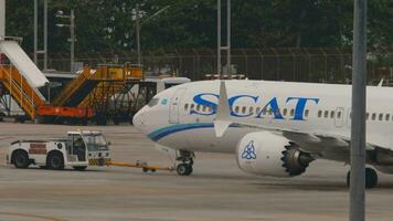 Phuket, Thaïlande février 26, 2023 - passager avion de scat à phuket aéroport. vol avoir prêt à prendre désactivé. aéroport Personnel sur le aérodrome. remorqueur tirant avion video