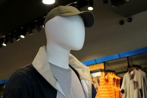 A mannequin stands on a display window in a supermarket. photo