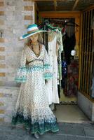 A mannequin stands on a display window in a supermarket. photo