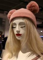 A mannequin stands on a display window in a supermarket. photo
