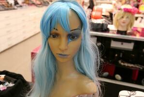 A mannequin stands on a display window in a supermarket. photo