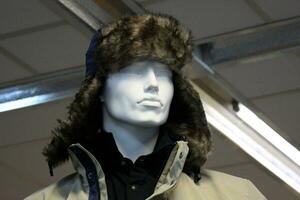 A mannequin stands on a display window in a supermarket. photo