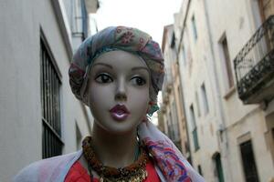 A mannequin stands on a display window in a supermarket. photo