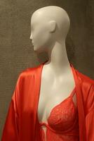 A mannequin stands on a display window in a supermarket. photo