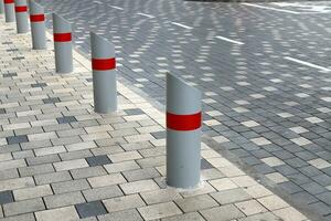 A row of pillars along the road for the safe passage of pedestrians along the sidewalk. photo