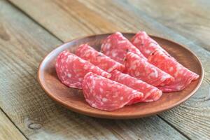 Slices of salami on the plate photo