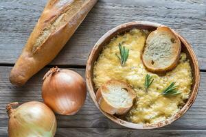 Bowl of onion soup on the wooden table photo