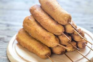 Stack of corn dogs on the wooden board photo