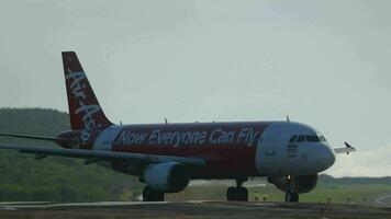 PHUKET, THAILAND NOVEMBER 28, 2014 - Airbus A320 AirAsia arriving at Phuket island. Airplane taxiing from the runway to the terminal. Concept tourism and travel video