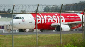 PHUKET, THAILAND NOVEMBER 27, 2015 - Lowcoster Airbus A320 of AirAsia taxiing on the runway at Phuket airport. Aircraft on the taxiway. Tourism travel concept video