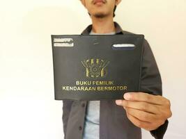 Indonesian book vehicle owners or commonly known as Buku Pemilik Kendaraan Bermotor BPKB. holding BPKB photo