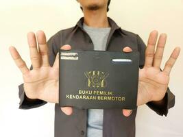 Indonesian book vehicle owners or commonly known as Buku Pemilik Kendaraan Bermotor BPKB. holding BPKB photo