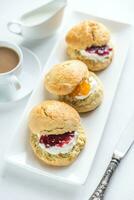 Scones with cream and fruit jam photo