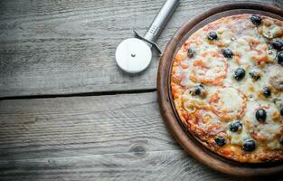 Cooked pizza on the wooden board photo