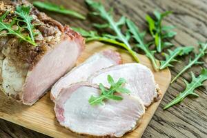 Baked meat with fresh rocket salad on the wooden board photo