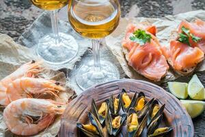 Seafood with two glasses of white wine on the wooden table photo