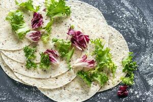 Tortillas with lettuce on a black surface photo